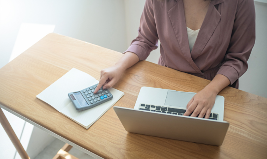 checking account header girl on laptop and calculator at desk
