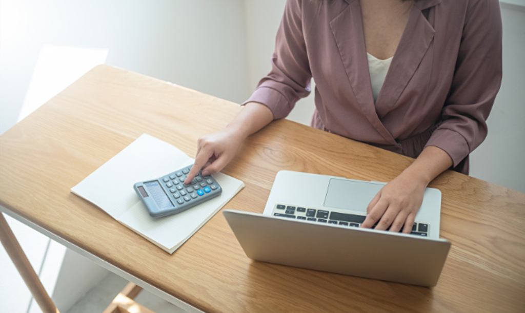 girl on laptop and calculator at desk