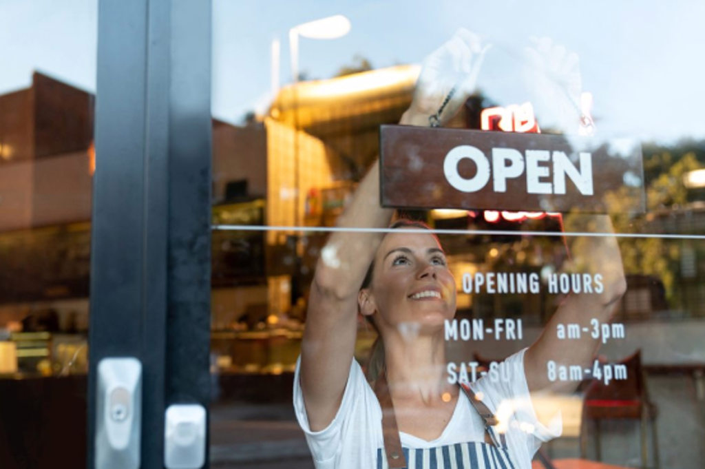 This image depicts a business owner hanging up an 