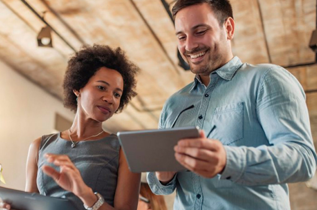 Service and Support Image depicts two coworkers talking while looking at a tablet computer