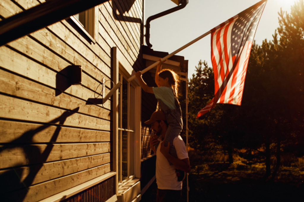 house with flag little girl and dad