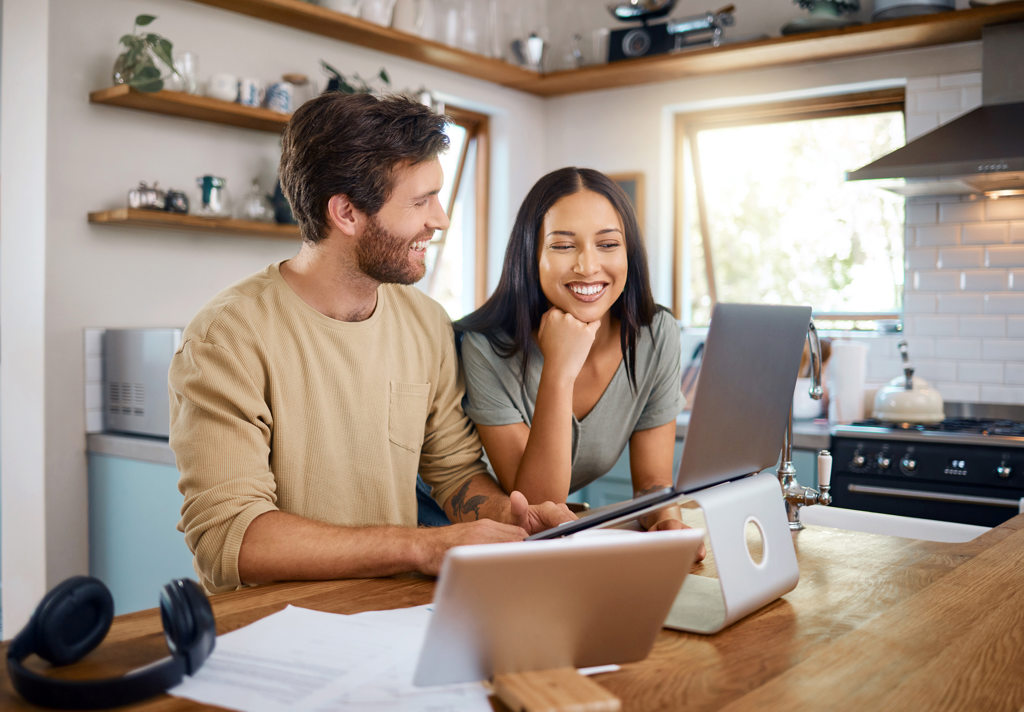 Online Account Open Header Couple at kitchen island on laptop smiling