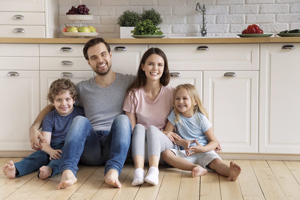 family sitting on kitchen floor smiling