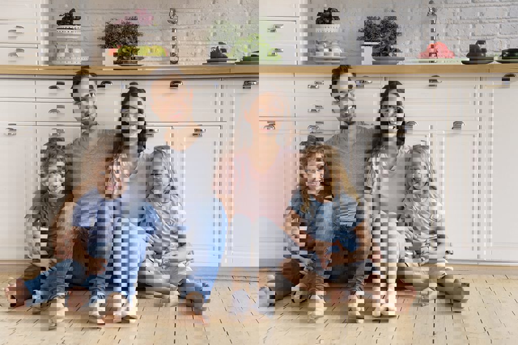 personal loan header family sitting on kitchen floor smiling