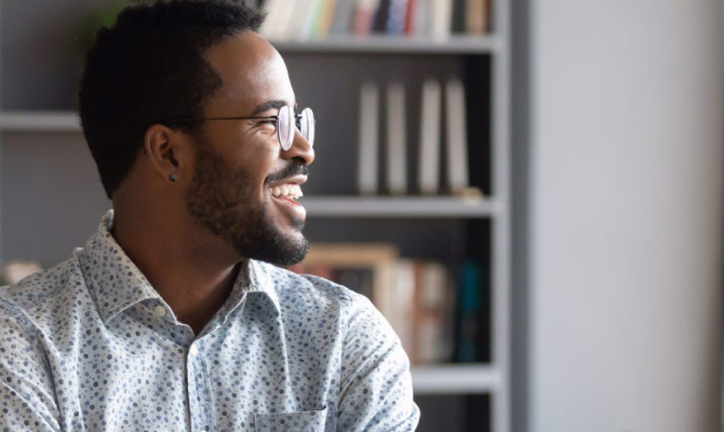 SBA Loans Image depicts a man with glasses smiling and looking off to the right.