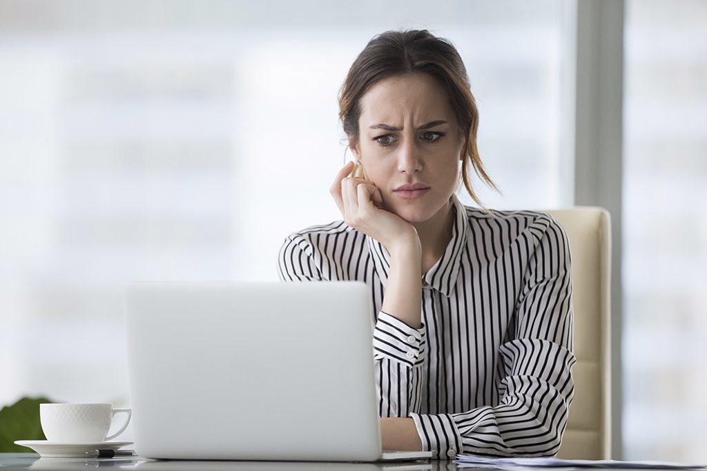 scam alert woman girl at laptop looking confused