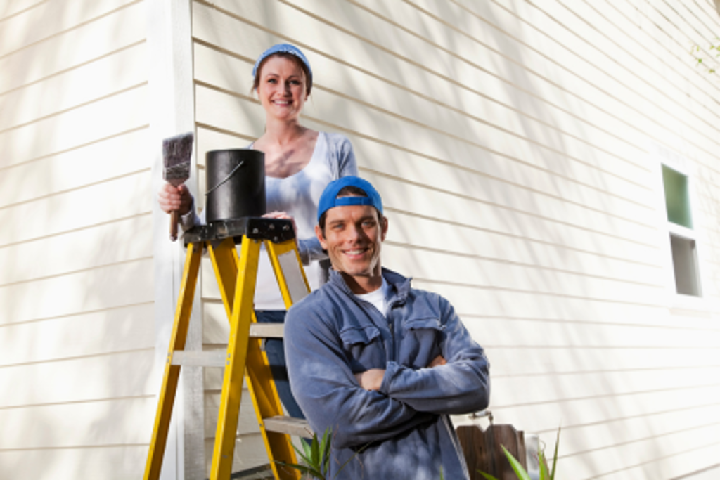 couple painting outside of house